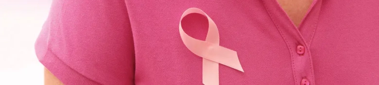 A charity worker with a lavender ribbon pinned to her shirt symbolising cancer support.